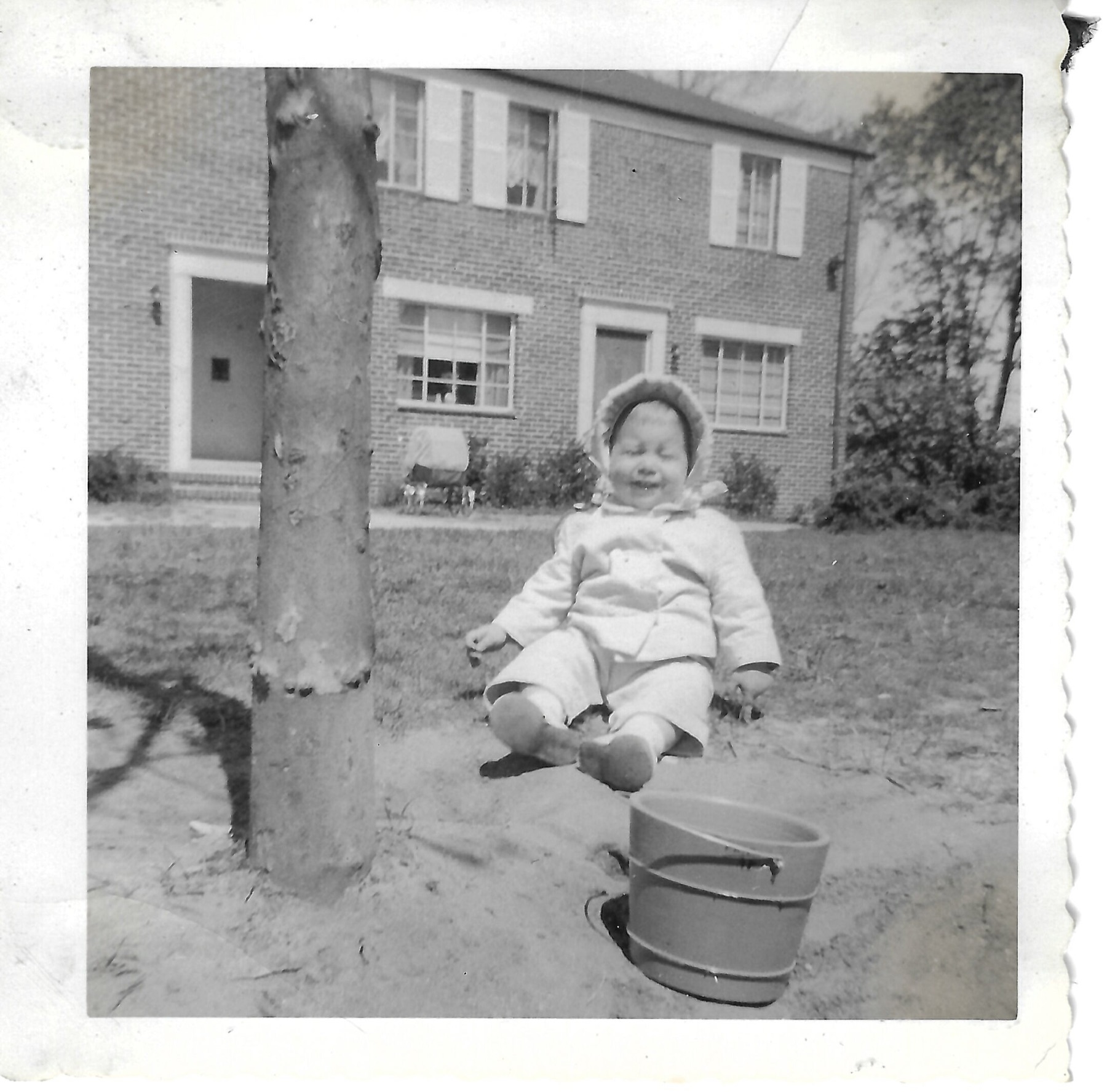 Young Betty outdoors beside a tree
