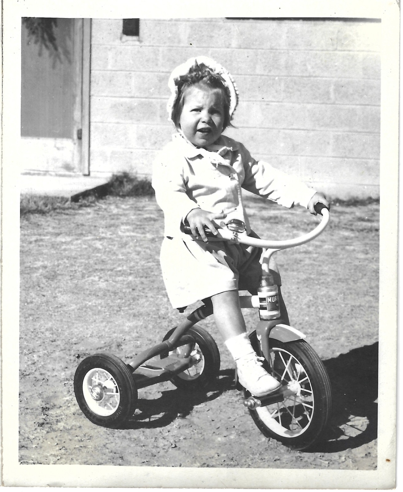 Betty on a tricycle on the lawn
