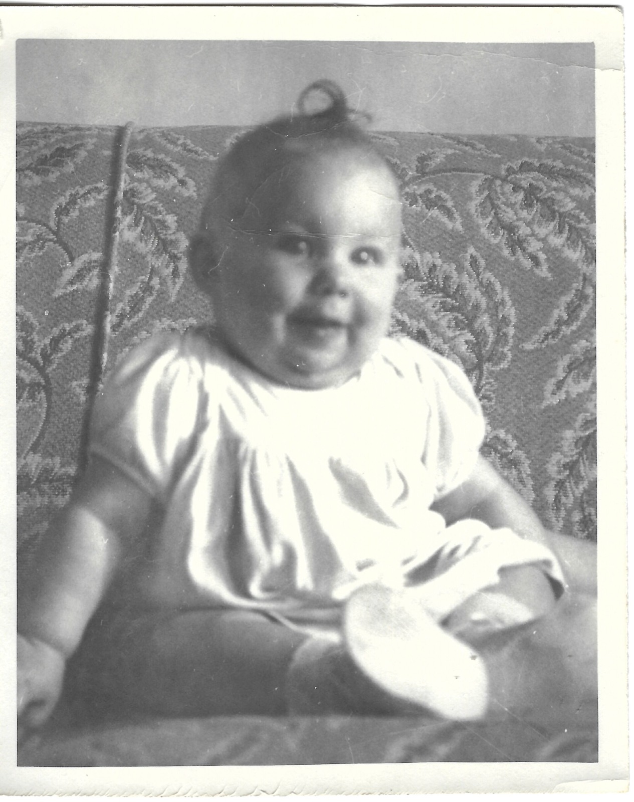 Baby Betty seated on a couch