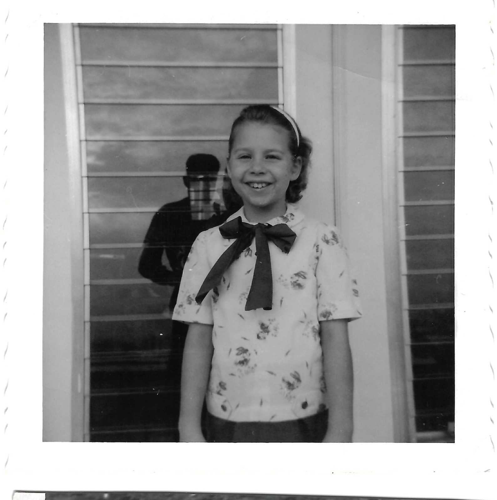 Young Betty by a house window