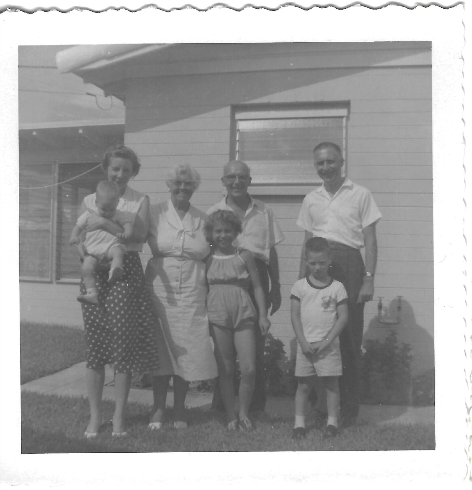 Newman family beside a house
