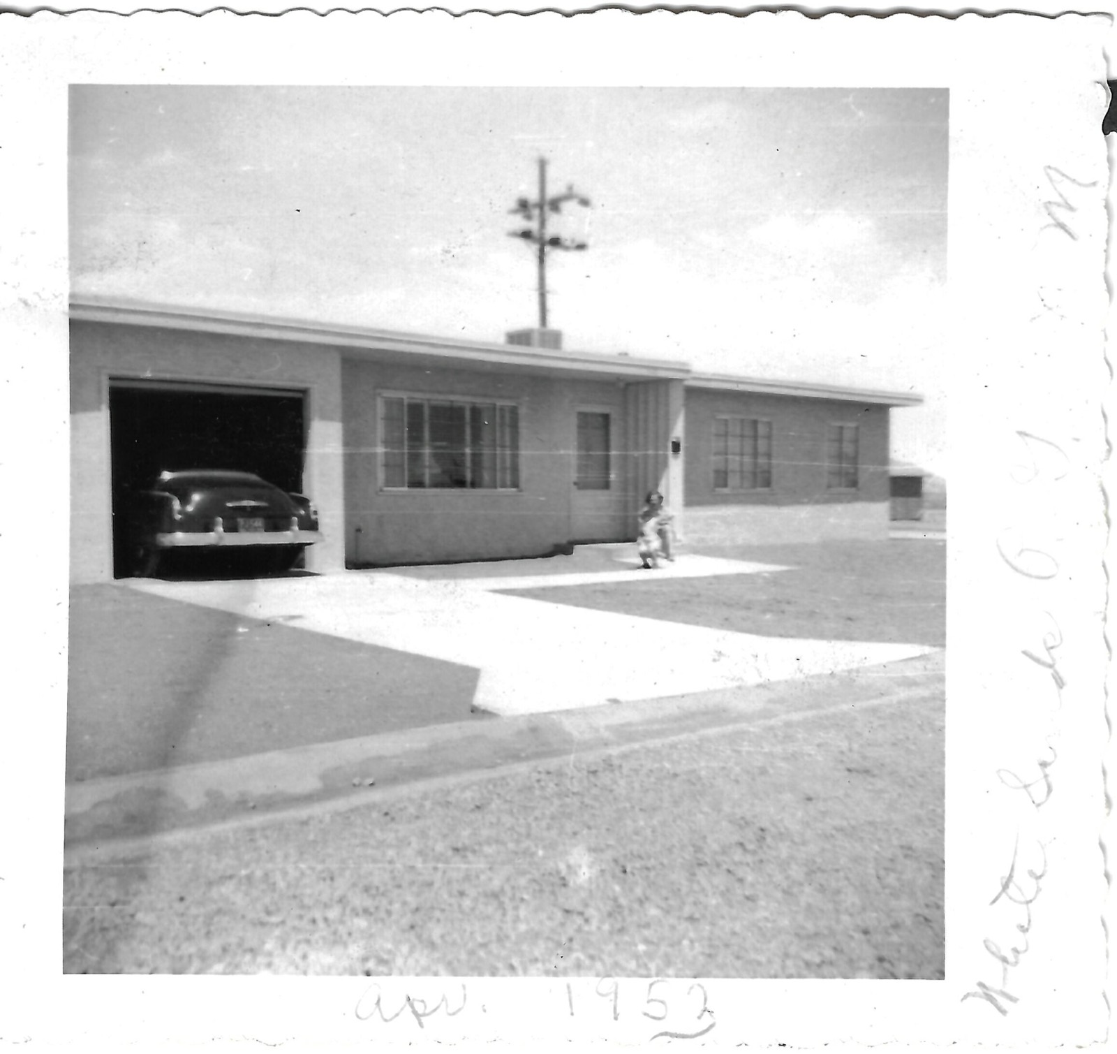 Child outside a family house and open garage