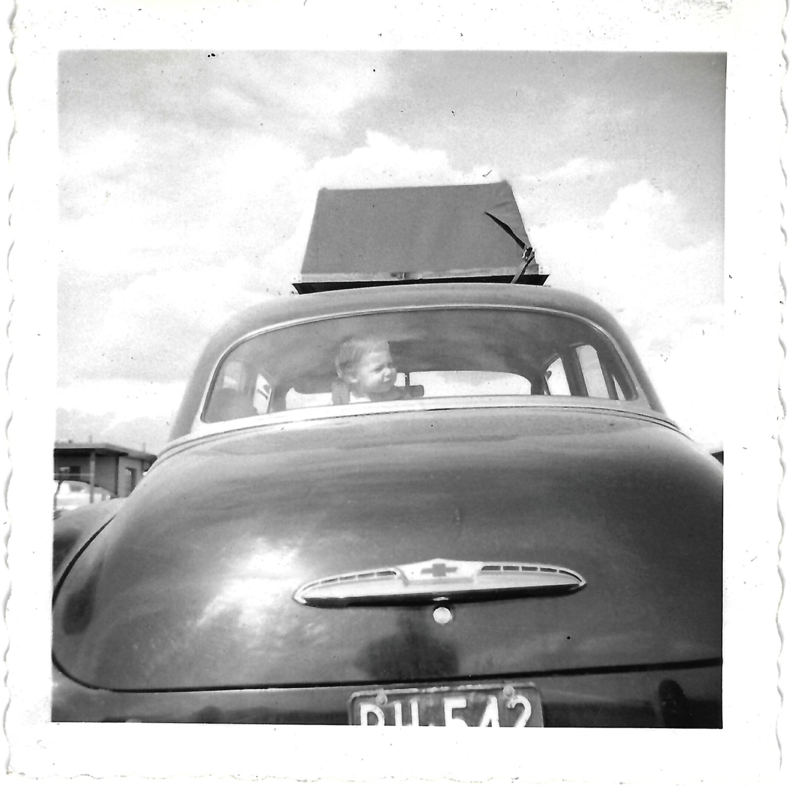 A second view of Betty through the family car’s rear window at White Sands; family-linked to April 1953.