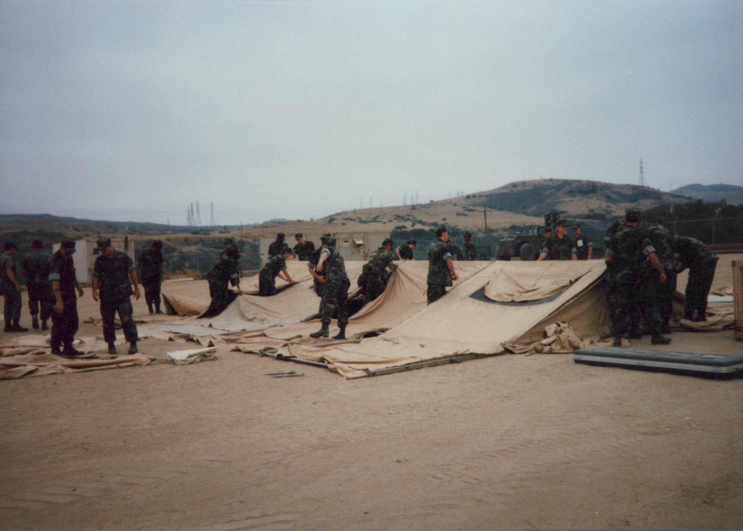 Fleet Hospital 007: People spread a large section of tent fabric across the ground.