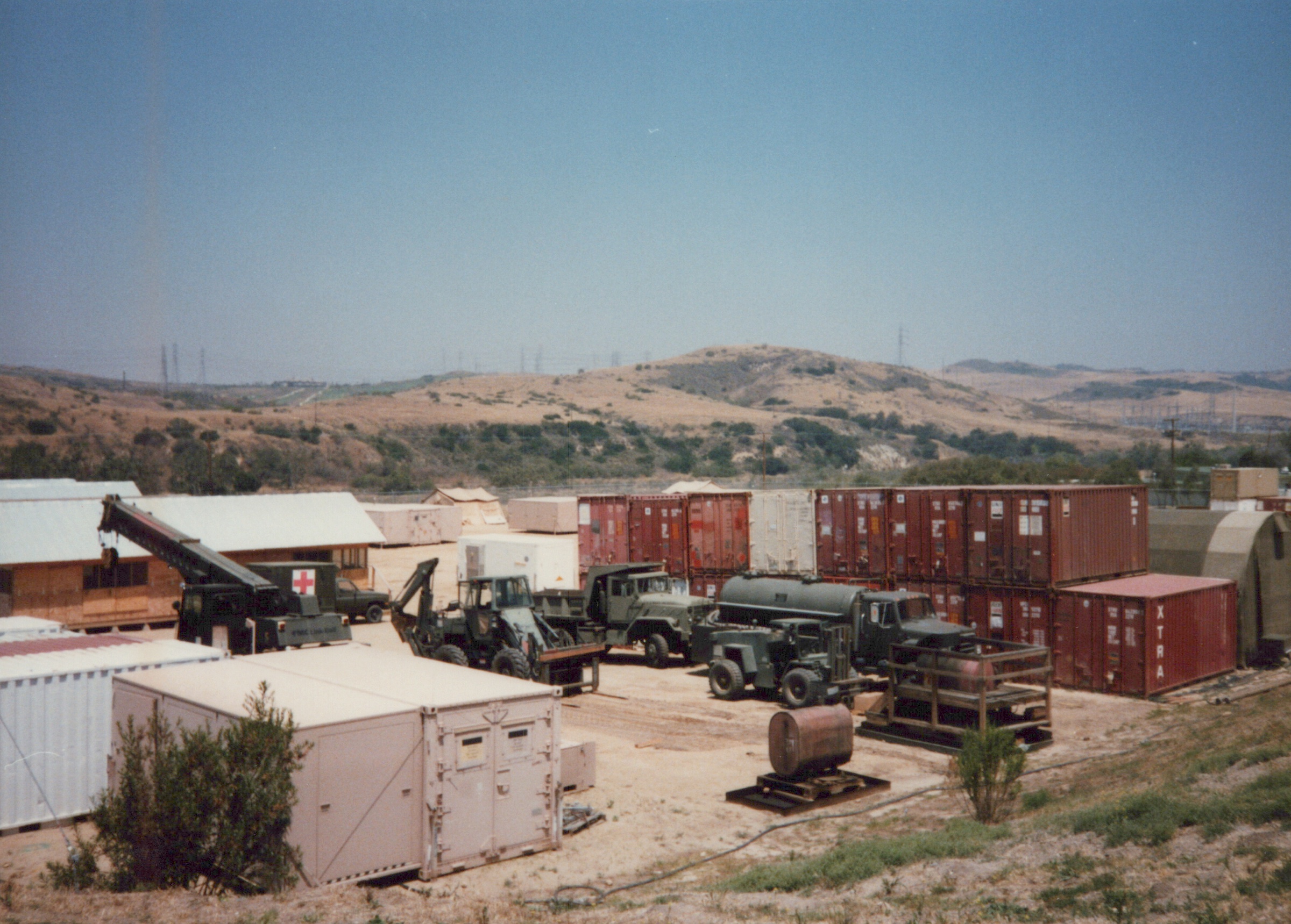 Fleet Hospital 007: Shipping containers, vehicles, and temporary structures across the site.